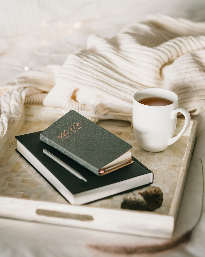 Mug of tea with journals on a tray